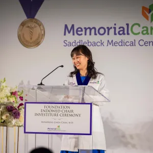 A doctor speaking at a ceremony
