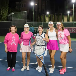 5 people standing on a tennis court