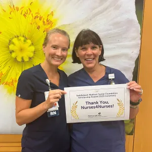 Two nurses holding a sign