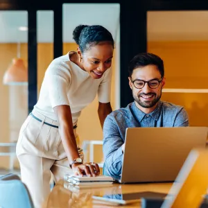 a man and women looking at a laptop screen