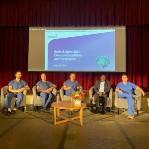 physicians sitting on chairs speaking at a panel