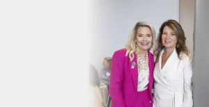 two women standing and smiling