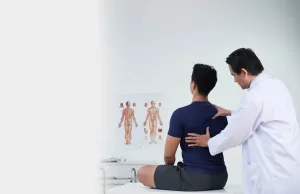 a doctor holding pressing on a patient back