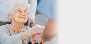 a senior smiling holding hands with physician